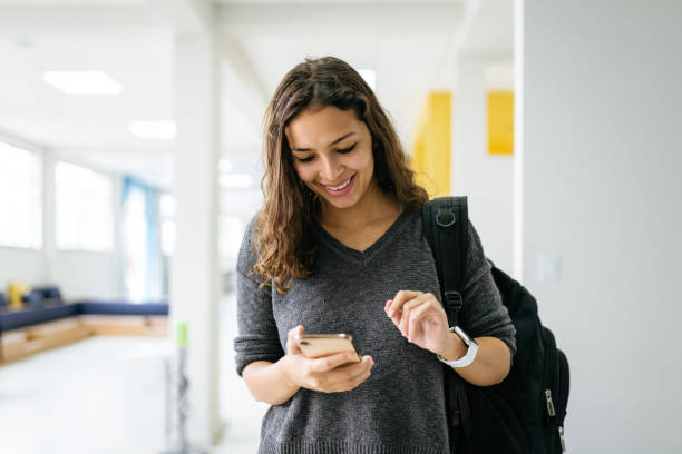 Young woman using smartphone at university